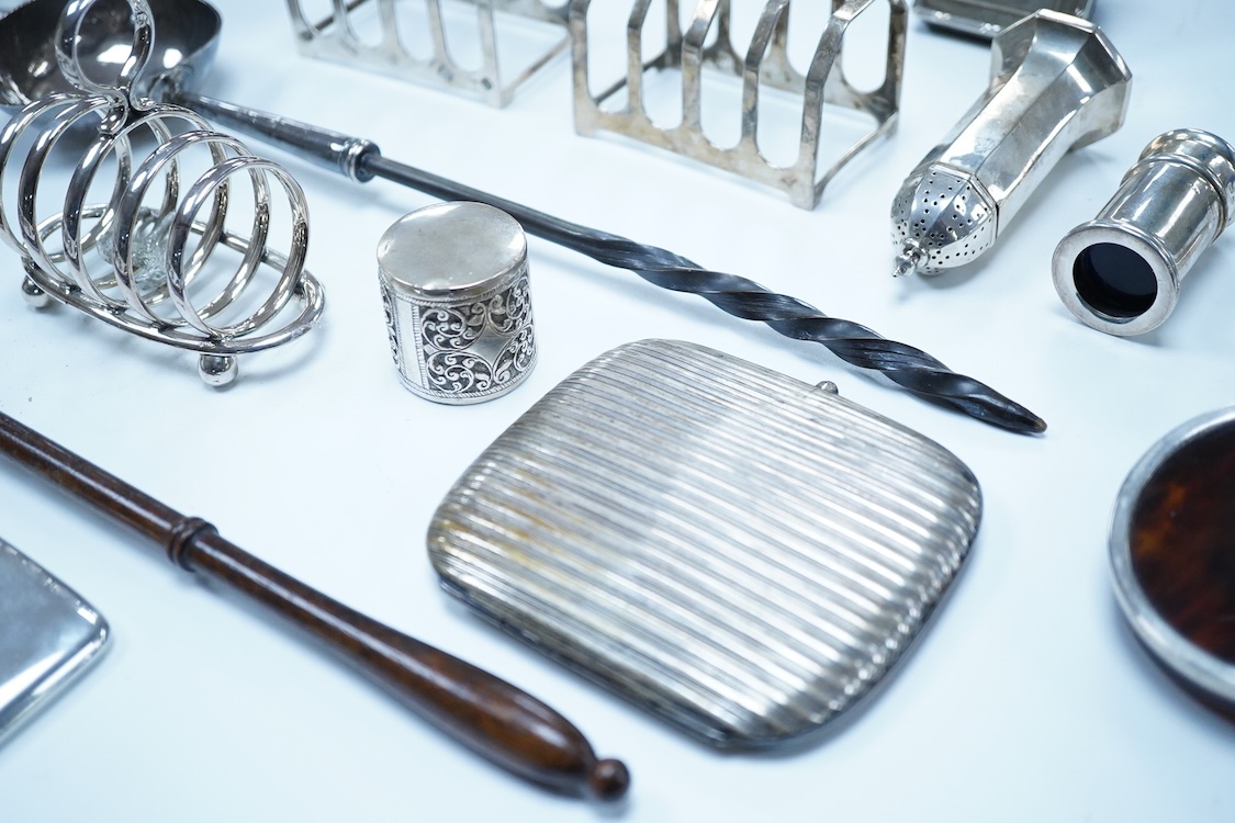 A group of assorted silver, to include a pair of modern five bar toast racks, a George V card case, a sterling vesta case, four assorted condiments, two mounted toilet bottles, mounted timepiece, a modern wooden handled
